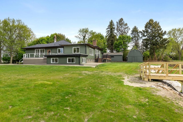3500 Lakeshore Dr, Saint Joseph, MI 49085 - rear view of house featuring an outdoor structure, a chimney, a yard, and a wooden deck
