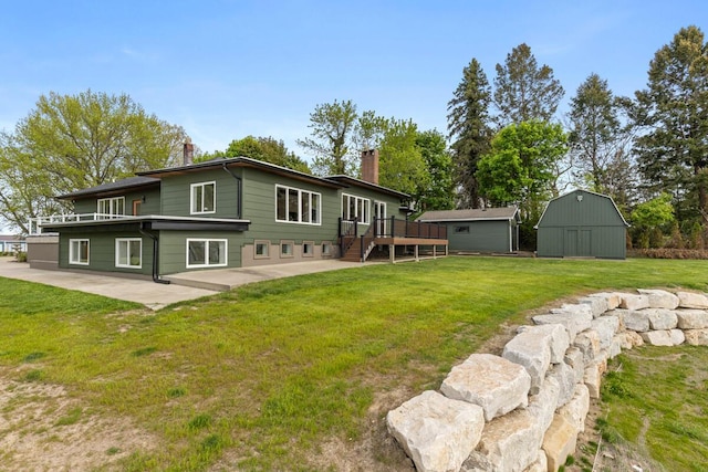 3500 Lakeshore Dr, Saint Joseph, MI 49085 - back of property with a chimney, an outdoor structure, a patio area, a lawn, and a wooden deck