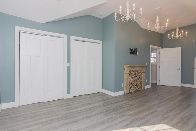 2106 Forest, Portage, MI 49002 - unfurnished living room featuring a chandelier, wood finished floors, baseboards, and high vaulted ceiling