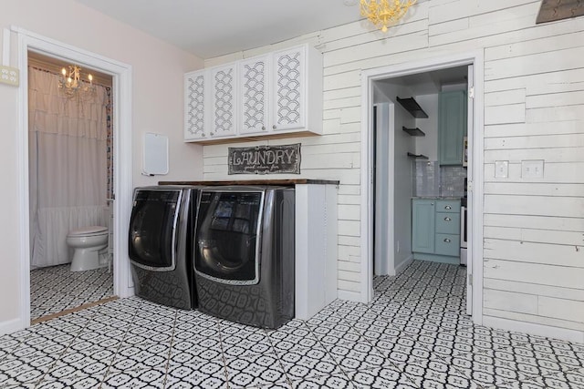 2106 Forest, Portage, MI 49002 - washroom featuring washing machine and dryer, a chandelier, wood walls, and tile patterned flooring