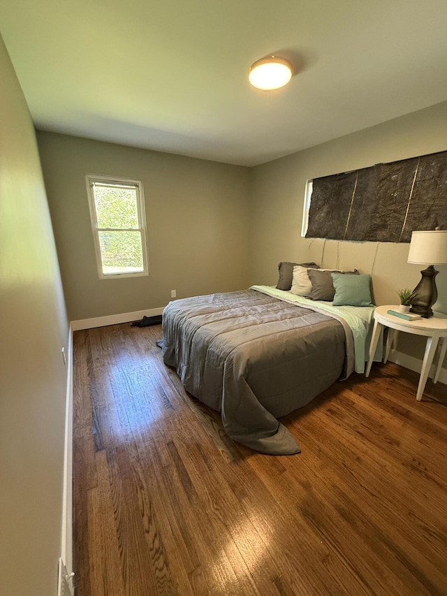 bedroom with wood finished floors and baseboards