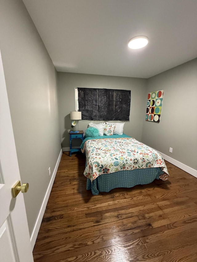 bedroom featuring baseboards and wood finished floors