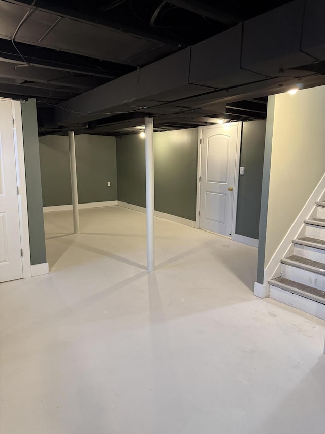 finished basement with stairway and baseboards