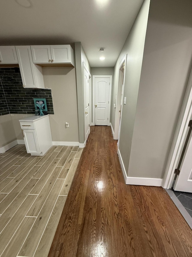 hallway with wood finished floors and baseboards