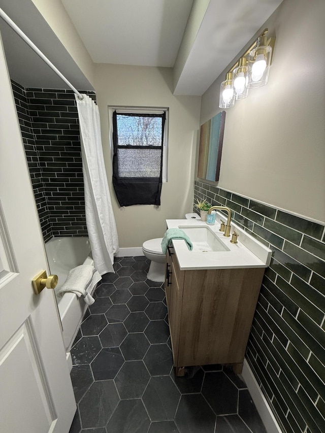 full bathroom with tile patterned flooring, toilet, vanity, shower / bath combo, and tile walls