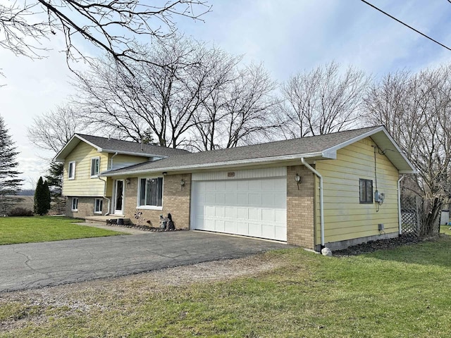2565 Carleton Rockwood Rd, Carleton, MI 48117 - tri-level home featuring brick siding, an attached garage, asphalt driveway, and a front yard