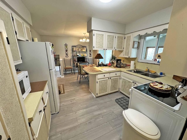 2565 Carleton Rockwood Rd, Carleton, MI 48117 - kitchen featuring white appliances, a sink, a peninsula, light wood-style flooring, and a chandelier