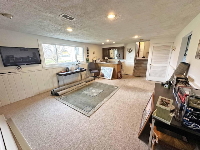 2565 Carleton Rockwood Rd, Carleton, MI 48117 - living room featuring a textured ceiling, carpet flooring, wainscoting, stairway, and recessed lighting