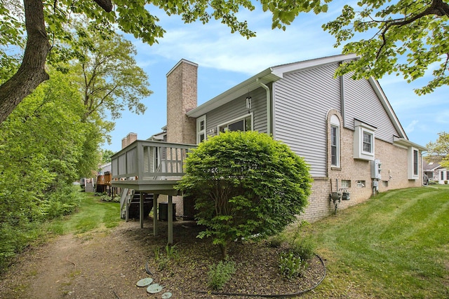 7343 Green Meadow Ln, Canton, MI 48187 - view of side of home featuring a yard, a wooden deck, a chimney, and brick siding