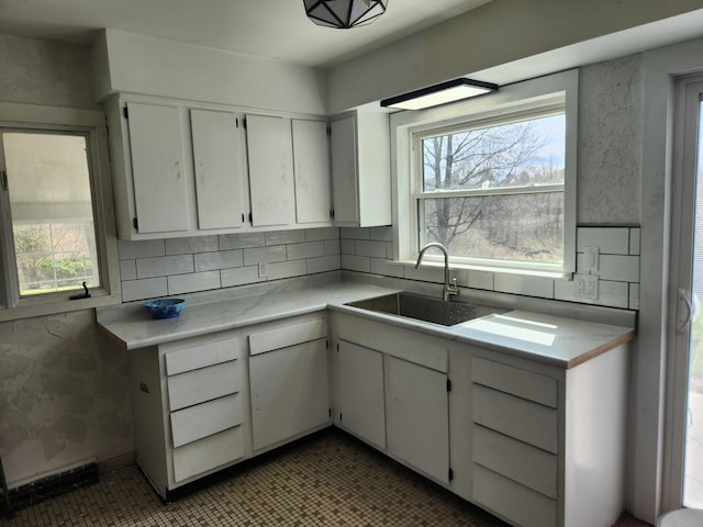 13851 Hillsdale Rd, Camden, MI 49232 - kitchen featuring a sink, light countertops, white cabinets, and decorative backsplash