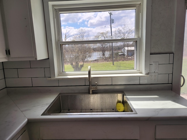 13851 Hillsdale Rd, Camden, MI 49232 - kitchen view of a sink, tasteful backsplash, and white cabinets