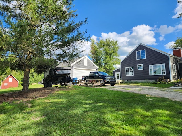 13851 Hillsdale Rd, Camden, MI 49232 - view of green lawn featuring dirt driveway and an outbuilding