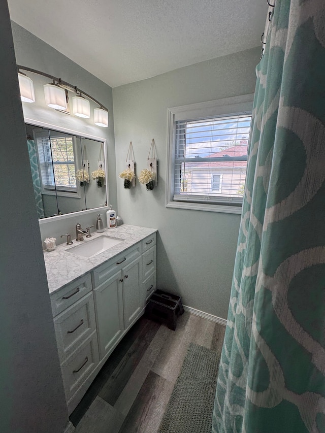 bathroom featuring wood finished floors, vanity, a textured ceiling, and a shower with shower curtain