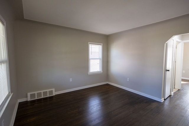 unfurnished room with dark wood finished floors and baseboards