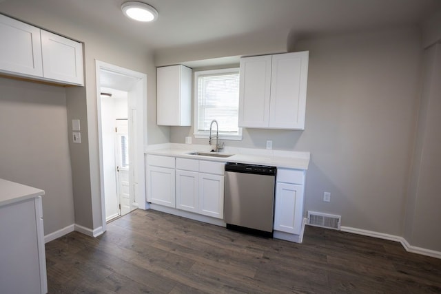 kitchen featuring stainless steel dishwasher, a sink, white cabinets, light countertops, and dark wood-style floors
