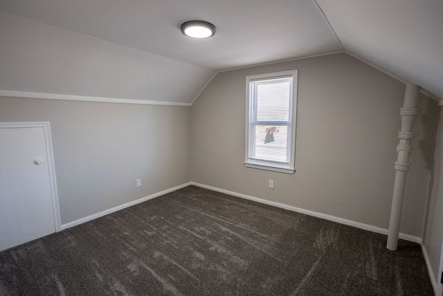 bonus room with lofted ceiling, dark carpet, and baseboards