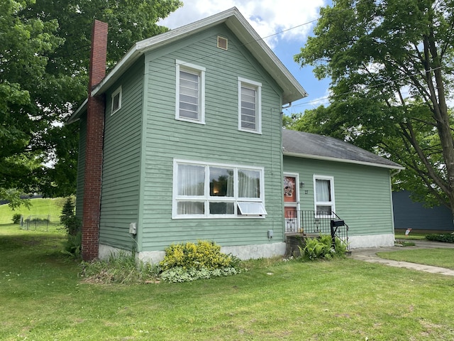 traditional-style home featuring a chimney and a front yard