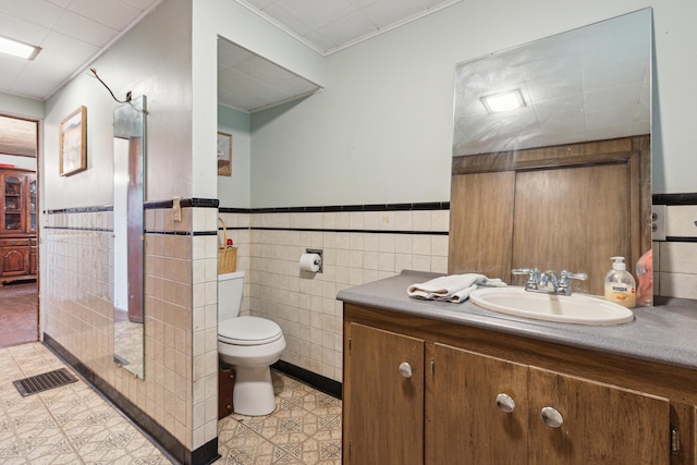 27 Hawley St, Quincy, MI 49082 - bathroom with vanity, toilet, tile walls, ornamental molding, and wainscoting