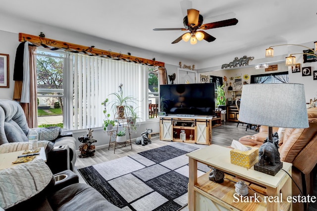 living room with wood finished floors and a ceiling fan