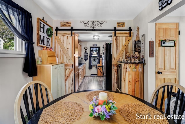 unfurnished dining area with a barn door and light wood-type flooring