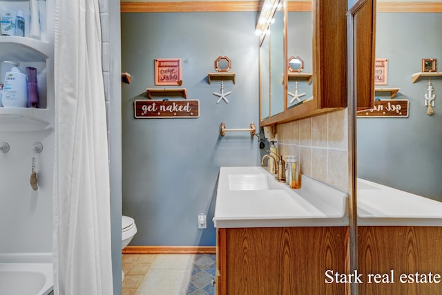 bathroom featuring toilet, vanity, tasteful backsplash, tile patterned floors, and baseboards