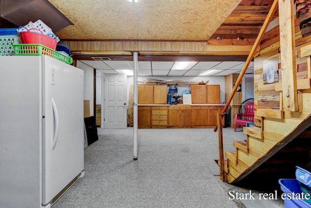 finished below grade area with freestanding refrigerator, carpet floors, and stairway