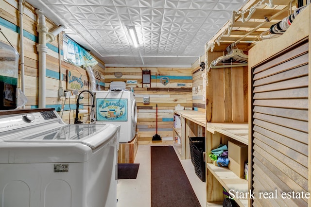 laundry area featuring wooden walls, washing machine and clothes dryer, and an ornate ceiling