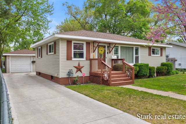 view of front of home featuring an outdoor structure, driveway, a detached garage, a front yard, and roof with shingles
