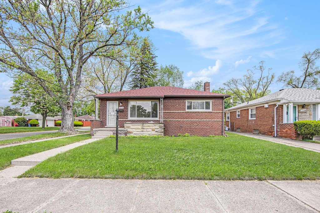 20110 Westbrook St, Detroit, MI 48219 - view of front facade featuring a chimney, a front lawn, and brick siding