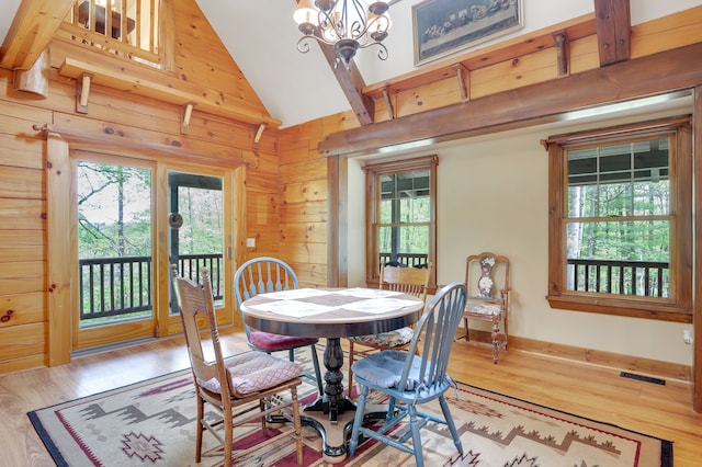 3118 Pratt Ln, Attica, MI 48412 - dining space with lofted ceiling, light wood finished floors, a chandelier, and wooden walls