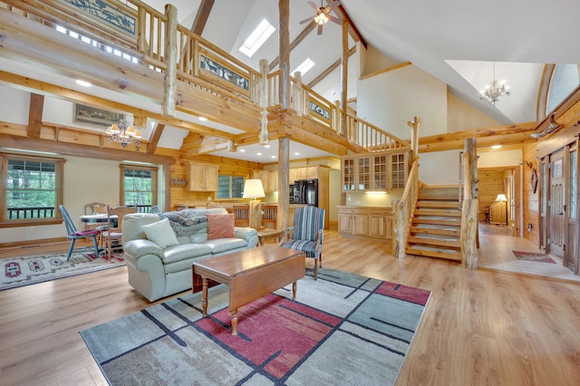 3118 Pratt Ln, Attica, MI 48412 - living area featuring a chandelier, light wood-style flooring, stairs, and high vaulted ceiling