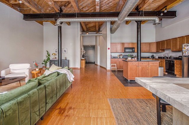 living room featuring a high ceiling and light wood-style floors