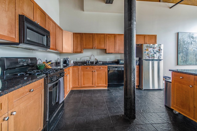 kitchen featuring black appliances, a sink, a towering ceiling, dark stone counters, and brown cabinets