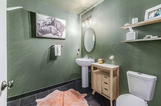 half bath featuring toilet, tile patterned flooring, and baseboards