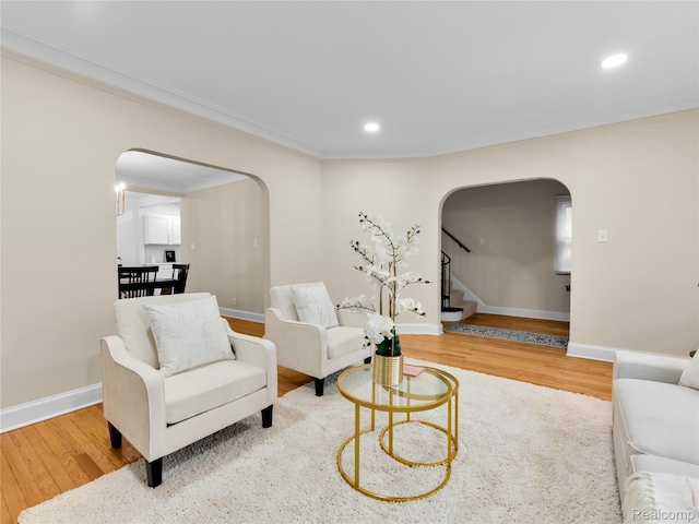 17524 Woodingham Dr, Detroit, MI 48221 - living room featuring arched walkways, wood finished floors, recessed lighting, ornamental molding, and stairway