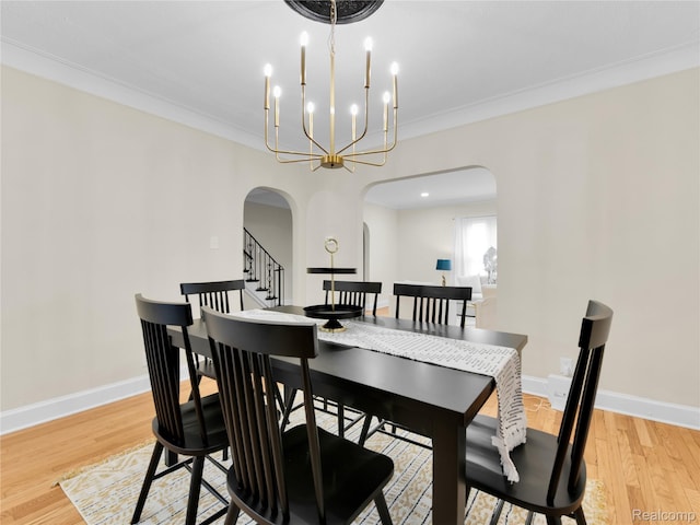 17524 Woodingham Dr, Detroit, MI 48221 - dining room with arched walkways, light wood-style flooring, baseboards, a chandelier, and crown molding