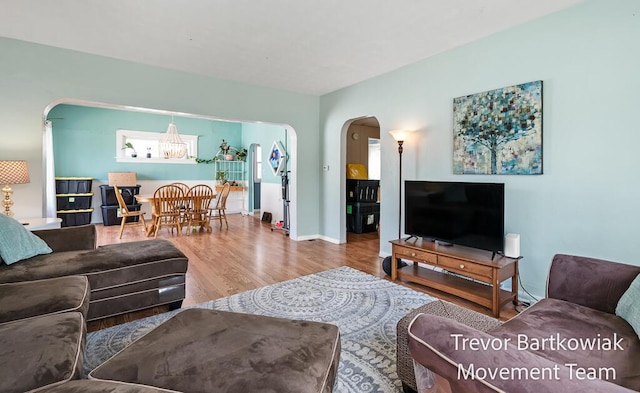2200 Morton Ave, Muskegon, MI 49441 - living area featuring arched walkways, wood finished floors, a chandelier, and baseboards