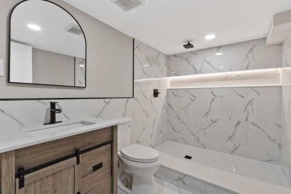 full bathroom featuring marble finish flooring, tile walls, vanity, toilet, and a marble finish shower