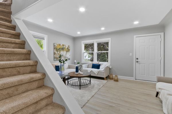 living area featuring stairs, wood finished floors, recessed lighting, and baseboards