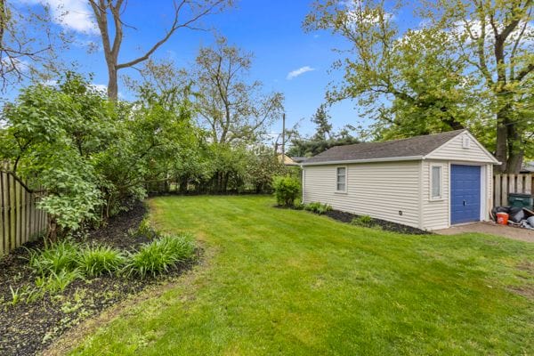 view of yard featuring an outbuilding, a detached garage, and driveway
