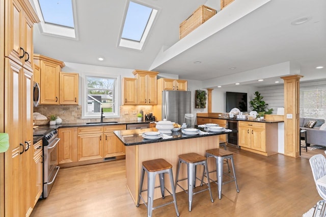 12147 Torrey Rd, Fenton, MI 48430 - kitchen featuring appliances with stainless steel finishes, wine cooler, a kitchen bar, a center island, and light wood-style floors