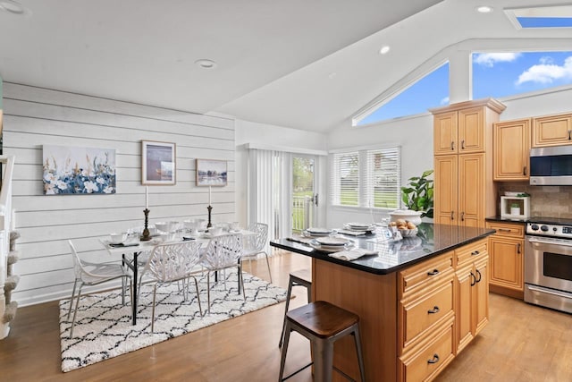 12147 Torrey Rd, Fenton, MI 48430 - kitchen featuring stainless steel appliances, a kitchen breakfast bar, recessed lighting, decorative backsplash, and light wood-style flooring