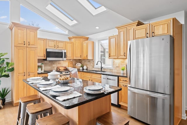 12147 Torrey Rd, Fenton, MI 48430 - kitchen featuring appliances with stainless steel finishes, a sink, a skylight, dark countertops, and lofted ceiling