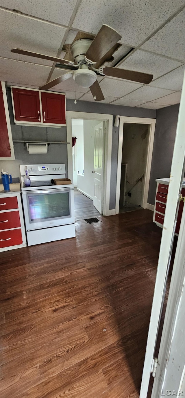 10320 Springville Hwy, Onsted, MI 49265 - kitchen featuring white electric range oven, ceiling fan, dark wood-style floors, a paneled ceiling, and light countertops
