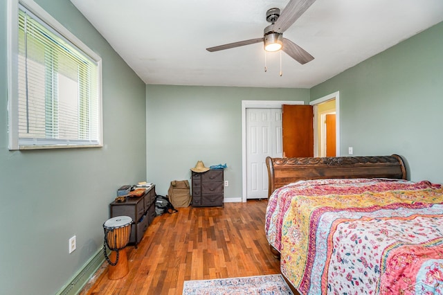 bedroom featuring baseboards, wood finished floors, and a closet