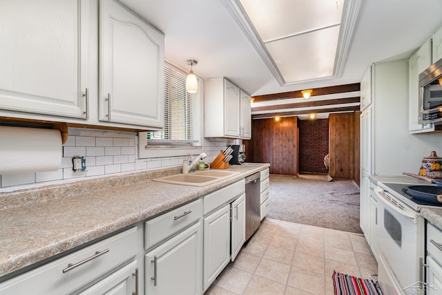 kitchen featuring a sink, stainless steel appliances, light carpet, and white cabinetry