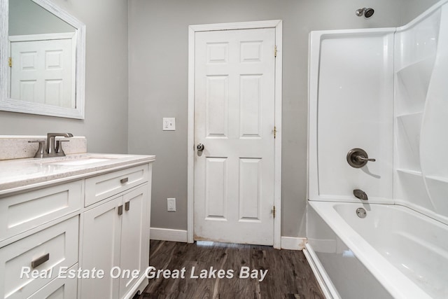 1006 Cass Ave, Bay City, MI 48708 - full bath featuring baseboards, wood finished floors, vanity, and shower / bath combination