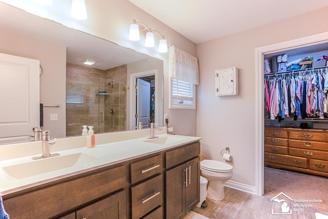 8265 Grande Lake Cir, Temperance, MI 48182 - bathroom with a stall shower, toilet, double vanity, and a spacious closet