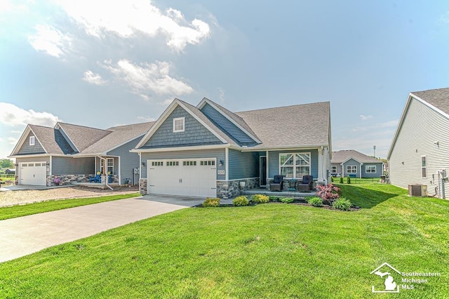 8265 Grande Lake Cir, Temperance, MI 48182 - craftsman inspired home featuring a garage, a porch, a front yard, concrete driveway, and stone siding