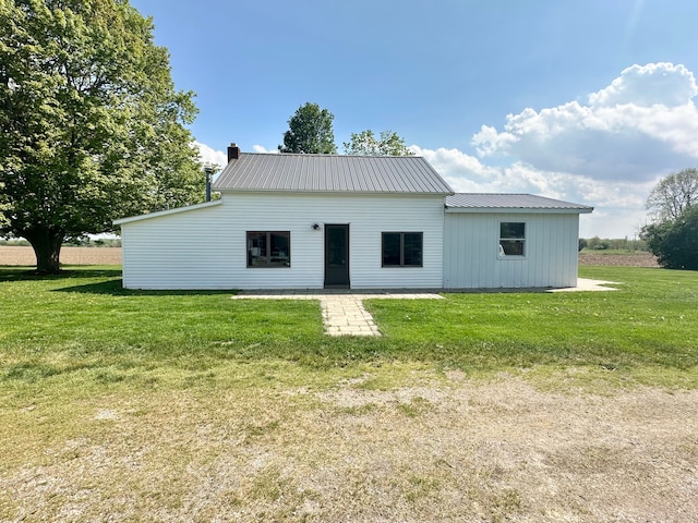 9548 Sharp Rd, Clifford, MI 48727 - back of property featuring a lawn, metal roof, and a chimney